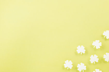 Happy St. Patricks Day decoration background. Flat lay of cutting paper clover leaves festive decor, shamrocks leaves holiday symbol with copy space on colour background, Banner greeting card conceptの写真素材