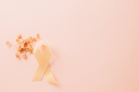 Pink awareness ribbon sign and paper card flower of World Cancer Day on pink background with copy space, concept of medical and health care support, Breast cancer awareness concept, 4 Februaryの写真素材