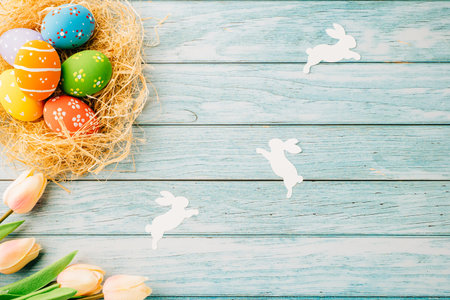 Top view holiday banner background web design white easter eggs in brown nest on blue wooden...