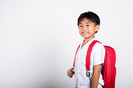 Asian adorable toddler smiling happy wearing student thai uniform standing in studio shot isolated on white background, Portrait little children boy preschool, Happy child Back to schoolの写真素材