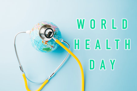 World Health Day Concept. Top view yellow doctor stethoscope and world globe isolated on pastel blue background with copy space, Save world day, Environment Green Earth, Health care and medicalの写真素材