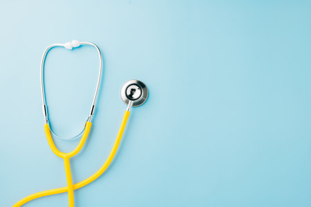 Yellow medical stethoscope isolated on blue background with copy space for you text, Doctor equipment, Overcoming the disease, Doctor Day Conceptの写真素材