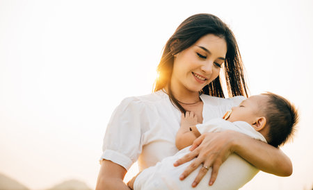 Portrait of a contented mother holding her sleeping son in a serene garden. Her face beams with joy...