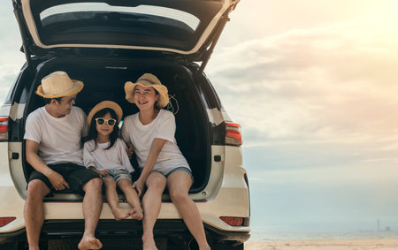 People enjoying road trip sitting down on back their car, Parents and children traveling in holiday at beach, family having fun in summer vacation on beach blue sky, Happy Family and World Tourism Dayの写真素材