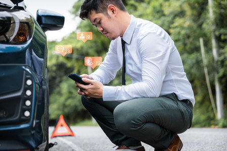 Businessman calling roadside assistance after his car broke down on the road. Waiting for help and...