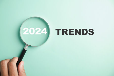 The image features magnifier glasses with the text New Year 2024 Trends, emphasizing the main trend of change. It represents the evaluation methods, popular topics, and new trends in business.の写真素材