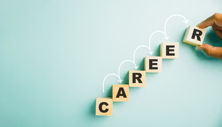 Hand meticulously positions a wooden cube block adorned with the word CAREER. This image symbolizes the opportunities, challenges, and growth associated with business successの写真素材