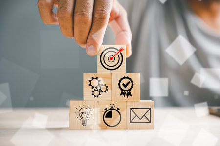 Businessmans hand strategically arranging wood blocks, symbolizing business strategy, Action plan, and goal targeting. Illustrating the concept of business development.の写真素材