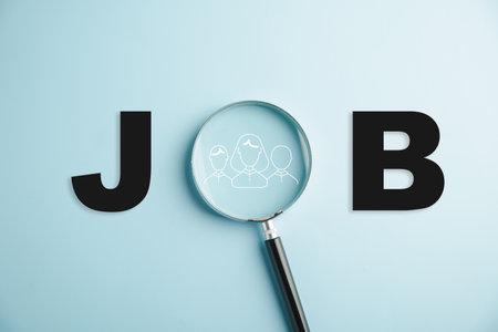 Close-up of a magnifying glass revealing JOB text, representing dedication and attention to detail required in job search journey to discover fulfilling career paths. job searchの写真素材