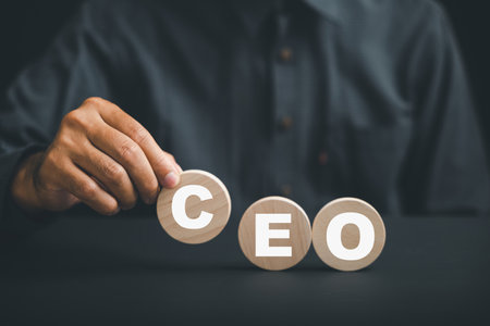 Businessmans hand picks up wooden circle with CEO text, symbolizing CEO. HR officer searches for leader and CEO. HR manager selects employee. Leader stands out from crowd. HR, HRM, HRD concepts.の写真素材
