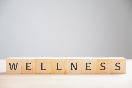 Wooden cube block features the word wellness, encapsulating concept of mental health, relaxation, and overall wellbeing. Ideal for promoting a healthy lifestyle and stress reduction. wellness conceptの写真素材