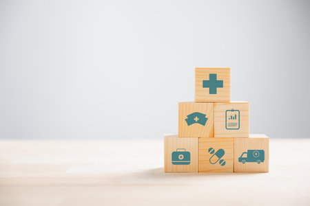 Symbolic image of healthcare and insurance portrayed through a pyramid of wooden cubes. Medical...