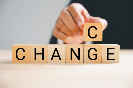 Flipping from CHANGE to CHANCE, businessman hand holds wood cube. Success, strategy, and opportunity concepts showcased. Vintage table setting enhances context. Change is.の写真素材