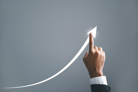 A businessman pointing hand guides an arrow on a graph, illustrating the corporate future growth...