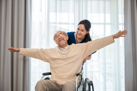 Happy curator person doctor pushing and walk elderly patient freedom raising arm at hospital, Asian...