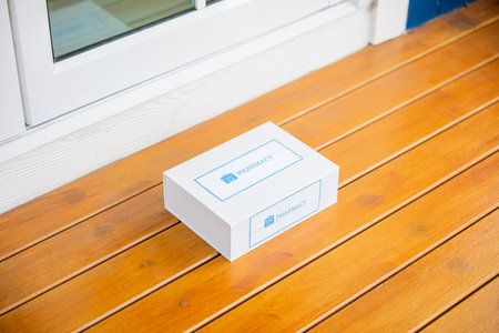 Buy online clinic retail Rx drug store, Medication package box Covid free first aid from pharmacy hospital delivery e-commerce on floor at door front home patient, online medical and healthcareの写真素材