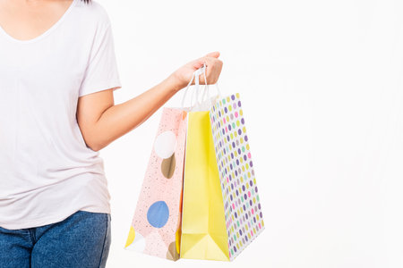 Closeup female holds in hand with multicolor clear empty blank craft paper gift bag, women hand...