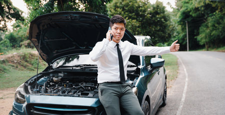 Stranded businessman calling for help after car breakdown. Candid shot of man in white shirt waiting...