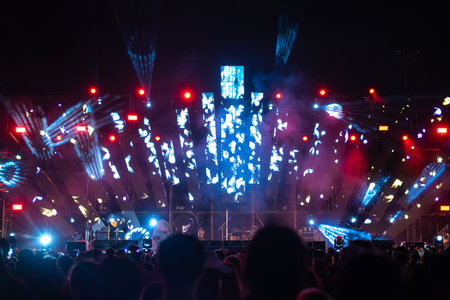 Amid vibrant nightlife concert festival main event features cheering crowd in front of brightly...