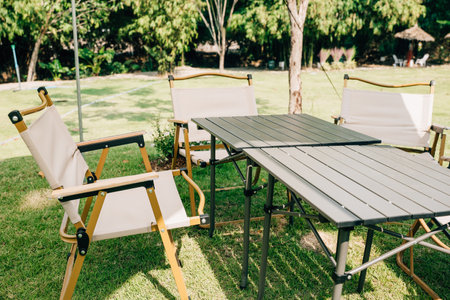 Experience the joy of outdoor camping with a tent, tables, and chairs for your summer picnic. This suburban patio setup provides comfortable seating and shade, perfect for relaxation.の写真素材