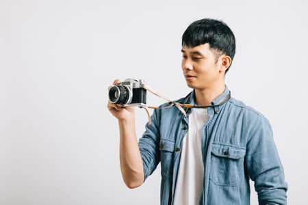 Glamorous portrait of a young man looking dashing as he poses for a vintage camera. Studio shot isolated on white background. The film-inspired snapshot is perfectionの写真素材
