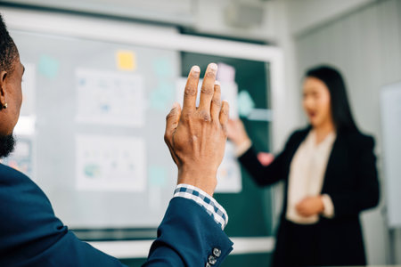 In a diverse meeting room colleagues raise their hands in cooperation exclusive businesswoman,...