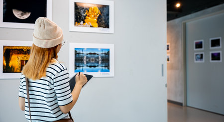 Young person at photo frame write digital book leaning against at show exhibit artwork gallery,...