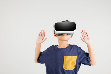 Portrait Asian smiling kid boy touching at something in a virtual reality glasses headset studio...