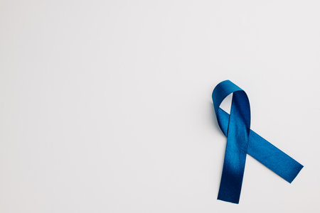 A bright blue ribbon, a symbol of world diabetes day on November 14, isolated on white. Copy space for messages of patient support and medical care.の写真素材