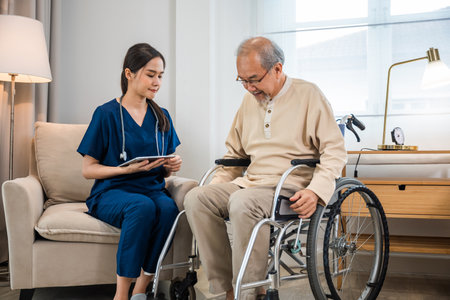 Asian woman doctor nursing holding digital tablet with patients chart while talking and explain for results of treatment to patient old man sitting in wheelchair, Health care and medicalの写真素材