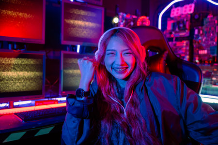 Winning. Happy Gamer young plays online video games computer she raises hands to wins tournament, young woman playing video game online at home feel excited, Hacker hacking completeの写真素材