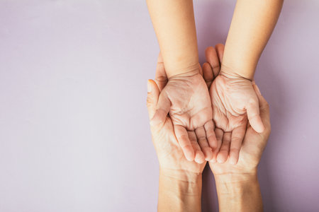 Top view of parents and kid holding empty hands together on a color background. Family day celebrating togetherness.の写真素材