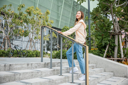 A businesswoman, in sneakers, embraces the city stairs, symbolizing her determined journey. Each step reflects her unwavering progress on the path to success and professional growth. step upの写真素材