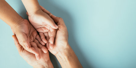 Family hands stack in close-up top view isolated background. Parents and kid hold empty space expressing support on Family and Parents Day.の写真素材