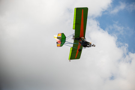 Stunt plane leaves smoke trail in thrilling aerobatic performance against blue sky. Skilled pilot...