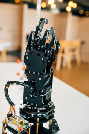 Futuristic black real robot hand makes contact on a table symbolizing artificial intelligence evolution. Conceptual image of technological advancement and innovation.の写真素材