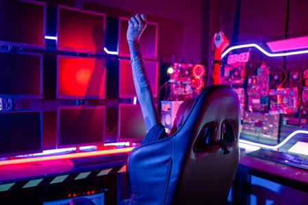 Winning. Young woman in gaming headphones playing video game online at home neon room feel excited, Happy Gamer young plays online video games computer she raises hands to wins tournament, E-Sportの写真素材