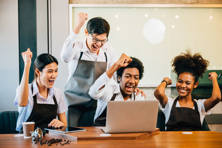 Diverse entrepreneurs have team meeting in stylish coffee shop. Barista owner discuss work on laptop. Multiethnic employees successful teamwork business strategy discussion.の写真素材