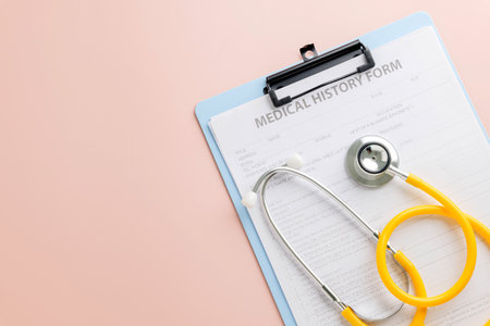 Celebrate Doctor Day with a clipboard holding a medical history form and a yellow stethoscope resting on it. Honoring doctors dedication to health, medicine, and patient care.の写真素材