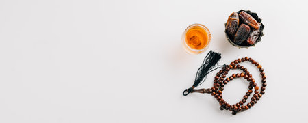 Ramadan flat lay, dates fruit, rosary beads, and tea on a clean white background. Celebrating the Muslim festival with traditional Arab elements. Ramadan celebrationの写真素材