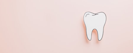 Dentist Day paper cut tooth mockup on pastel pink backdrop. Showcasing health, oral hygiene, orthodontic care, and white teeth design for dental-themed postcards and celebrations.の写真素材