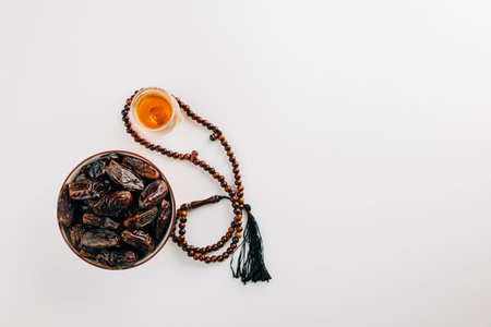 Ramadan decor, dates, tea, and rosary beads on a white background. Celebrating the Muslim holiday with a festive flat lay for the sacred month. Ramadan celebrationの写真素材