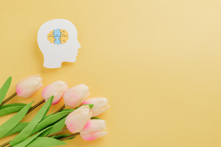 Yellow background features brain jigsaw in head paper cut with flower for Down Syndrome Day. Supporting Down Syndrome awareness and spreading hope across the world.の写真素材