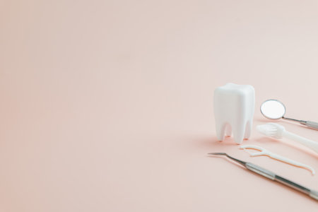 Celebrate Dentist Day with a teeth model and dentist tools on a pink background. Perfect for promoting World Oral Health Day and highlighting oral care essentials.の写真素材