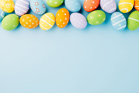 Overhead easter eggs isolated on blue background with copy space, Funny decoration, Happy Easter Day greeting card, Creative composition banner web design holiday background, flat lay top viewの写真素材