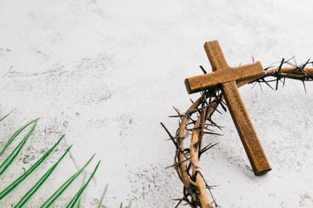 Palm Sunday traditions. Gray background scene with palm leaves, crown of thorns, and wooden cross. Symbolizing faithの写真素材