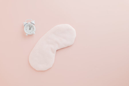 Celebrate World Sleep Day with an eye mask and clock on pink background. Promoting Sleep Day awareness and the importance of restful care and protection.の写真素材
