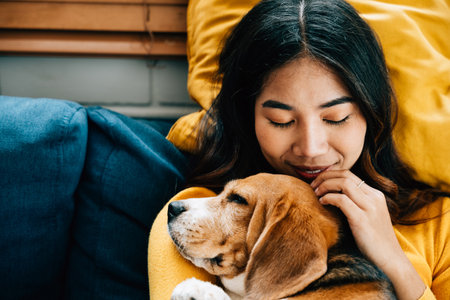 A portrait of happiness, a woman and her Beagle dog sleep peacefully on the sofa in the living room, embodying the concept of best friends forever and the joy of togetherness. Pet loveの写真素材