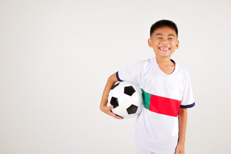 Portrait Asian smiling young boy kids holding soccer ball studio shot isolated white background, celebrating happy cute child player football, sport hobby for kids, leisure gamesの写真素材