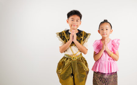 Portrait Thailand kid boy and girl smiling traditional Thai dress costume posing to pay respect in...